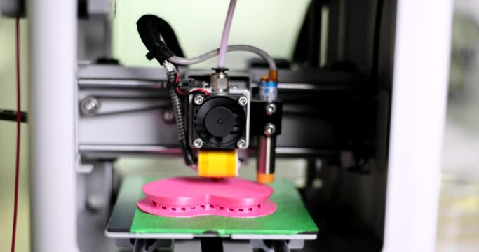 Fused deposition modeling 3D printer prints an object made of plastic. Automatic three-dimensional 3D printer makes heart out of plastic