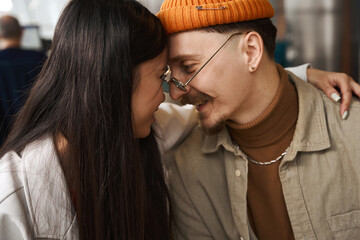 Woman in love embracing man in coworking space