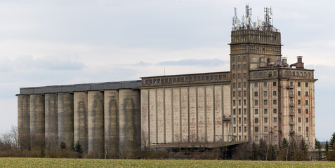 A huge concrete grain silo standing in a field. Warehouses full of grain before the new season © Fotoforce