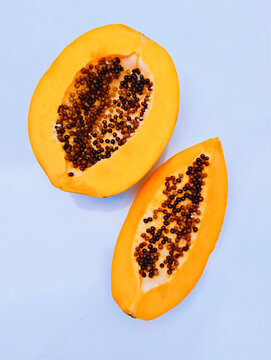 Ripe papaya slices with black seeds carica-papaya fruit raw papaw fresh pawpaw with yellow inner fleshy juicy whole papayya papeeta food closeup papaye lechoza cut half halved image mamao photo