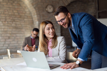 Caucasian business people working on laptop at office