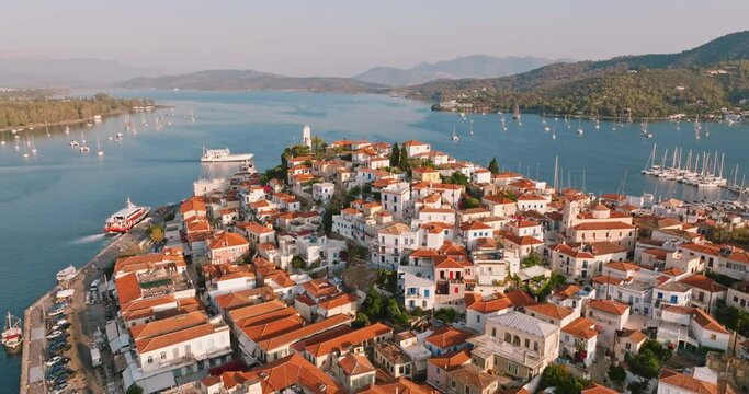 Poros island, Greece. Sailing yacht in marina at Aegean sea Aerial view of drone slide on beautiful panorama of golden sinrise sailing yachts high mountains of sea harbors summer. Travel. Tourism