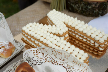 Sweet cake in form of letter. Delicious treat at fair. Cream on baked cakes.