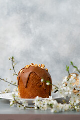 Cut Easter cake on plate decorated with spring flower branches