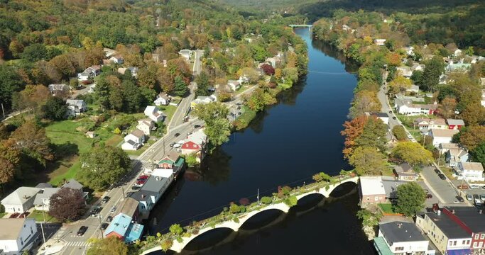 The Bridge of Flowers spans the Deerfield River with the rolling hills of Western Massachusetts as a backdrop in Shelburne Falls, MA during fall.
