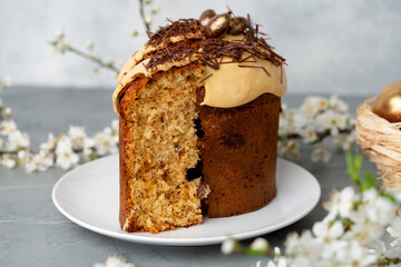 Cut Easter cake on plate decorated with spring flower branches