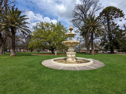 A view across Belmore Park in Goulburn, NSW, Australia towards an ornate fountain and mature trees.
