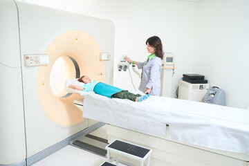 Female doctor conducting a CT scan of the brain of child
