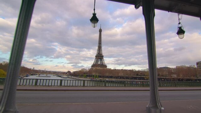  Aerial drone distant sunset view of Tour Eiffel Tower and Seine River bridge, Paris city attractions, France. Clouds in the background