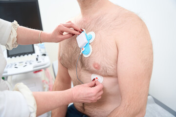 Male patient with sensors on his body to monitor arrhythmia