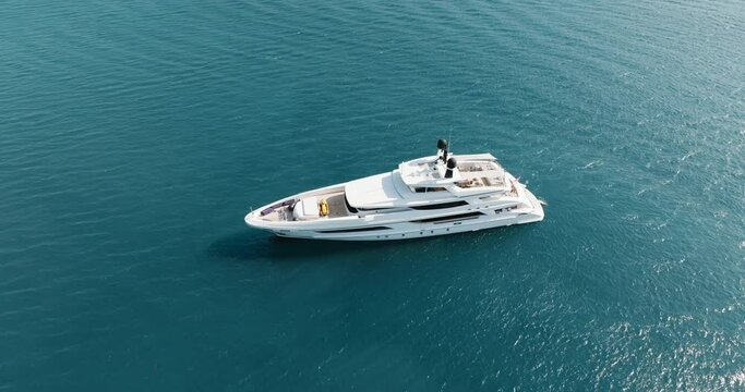 White motor luxury yacht drifts on calm surface aerial view of blue sea in Greece. Summer holidays. Sailing. Travel. Tourism