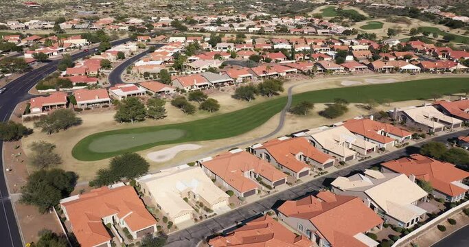Aerial view of a suburban residential community with a golf course in a desert environment with mountain backdrop near Tucson, Arizona.