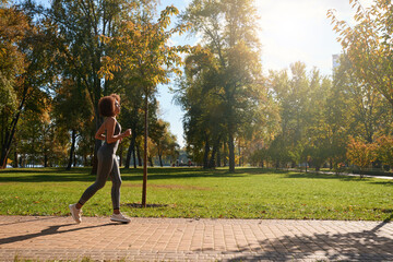 Slim young African American woman jogging in morning