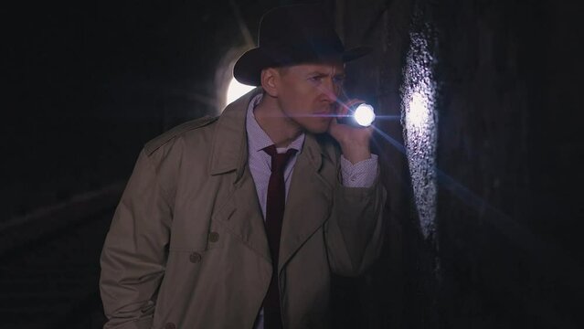 crime scene investigator private detective man flashlights retro style searches collecting evidence in the tunnel dark shot close up