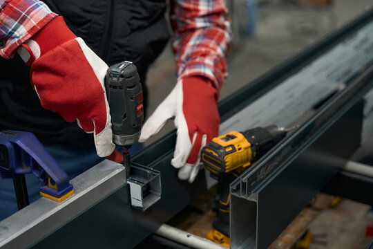 Close up photo of male assembling metal structure