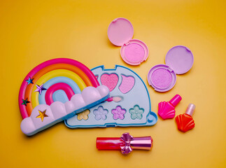 Children's set of decorative cosmetics for a little girl in the shape of a rainbow. Flat lay.