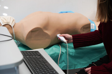 Students and their teacher during an echography simulation workshop on a robot mannequin.