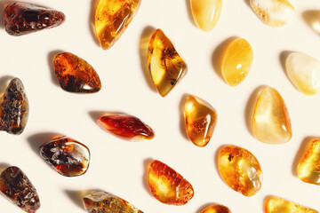 Amber stones at sunlight on beige background, minimal style pattern from transparent stones in...