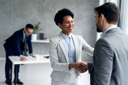 Smiling businessman and businesswoman handshake in office on a meeting - Powered by Adobe