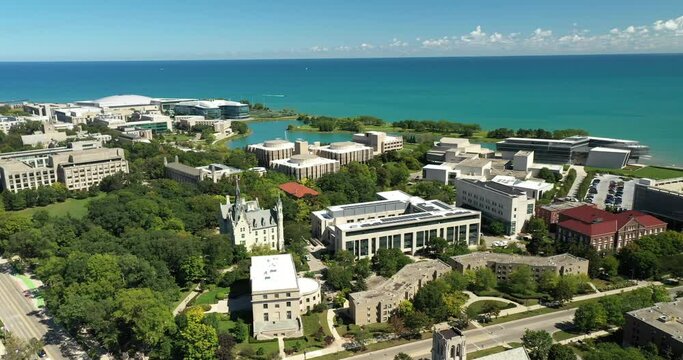 Aerial view of a suburban university along Lake Michigan with campus lagoon and fountains.