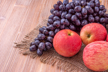 Different grapes and apples on a wooden background. Healthy food.