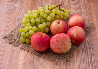 Different grapes and apples on a wooden background. Healthy food.