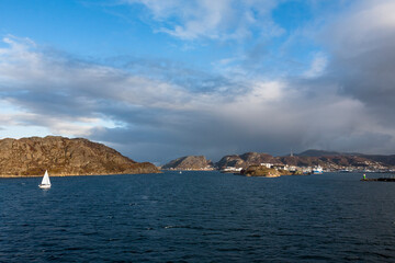 Fototapeta na wymiar A sailing yacht entering Bodø harbour, Nordland, Norway