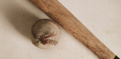 Old wooden ball bat with used ball for sports equipment on texture background.