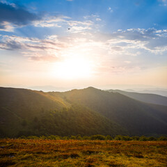 mountain valley in dense mist at the sunrise, early morning mountain landscape