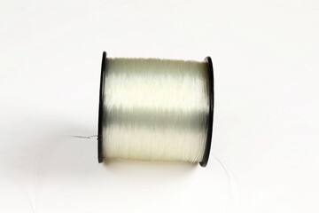 spool of transparent nylon thread can be used to make jewelry,clothing,craft or fishing line,white background with copy space