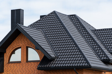 Roof of a new home. Roof covering with steel tiles. Modern roof made of metal