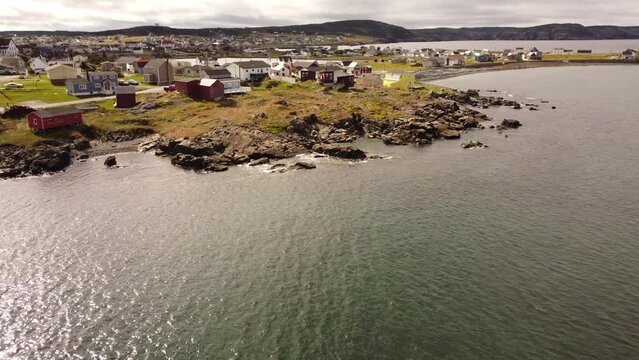 Aerial cinematic newfoundland revealing shot of colourful beach homes overlooking the Atlantic Ocean in the remote community of Bonavista Canada.
