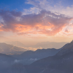 Fototapeta na wymiar mountain valley silhouette in blue mist under evening cloudy sky