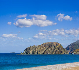 emerald sea bay with sandy beach under cloudy sky