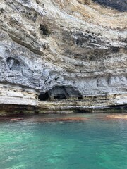 Rocky grotto with turquoise clear water, beautiful nature photo.