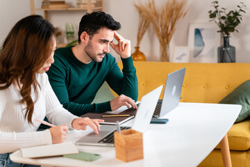 Happy couple working on laptop and making notes