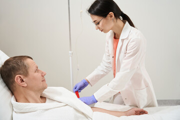 Caucasian doctor is preparing man for the examining blood in the hospital
