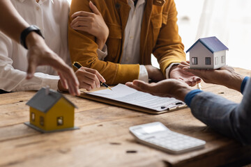 Family couple consultations with a lawyer or insurance House model with agent and customer discussing for contract to buy, get insurance or loan real estate or Mortgage property insurance.