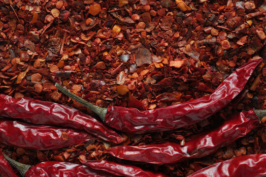 top view on ground dried chilli pepper flakes and whole chilli pods