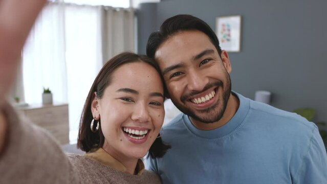 Couple taking selfie, living room house and vacation young love together. Asian woman and latino man, create social media video content and joke around happy home. New marriage smile, happiness laugh