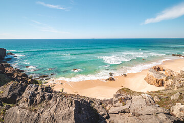Rocks surround the sandy beach of Praia do Malhao Sul on the Atlantic coast near Vila Nova de...