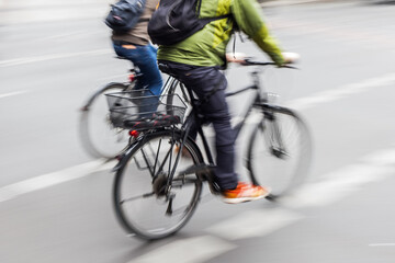 two bicycle riders on a city street iwith motion blur
