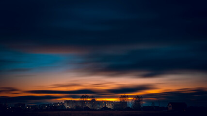Fototapeta na wymiar Clouds in motion at sunset over the city. Sunset over the city.