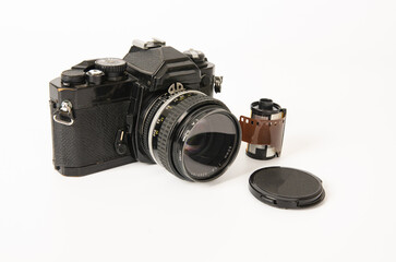 Photograph of a film camera and 35mm film on a white background
