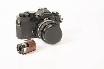 Photograph of a film camera and 35mm film on a white background