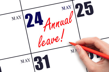 Hand writing the text ANNUAL LEAVE and drawing the sun on the calendar date May 24