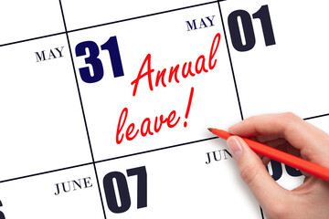 Hand writing the text ANNUAL LEAVE and drawing the sun on the calendar date May 31