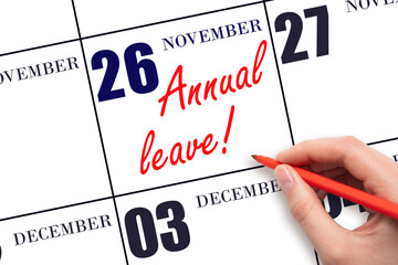 Hand writing the text ANNUAL LEAVE and drawing the sun on the calendar date November 26