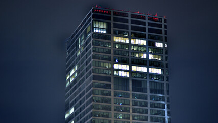 Pattern of office buildings windows illuminated at night. Glass architecture ,corporate building at...