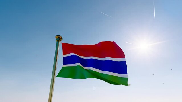 Flag of Gambia waving in the wind, sky and sun background. Gambia Flag Video. Realistic Animation, 4K UHD. 
